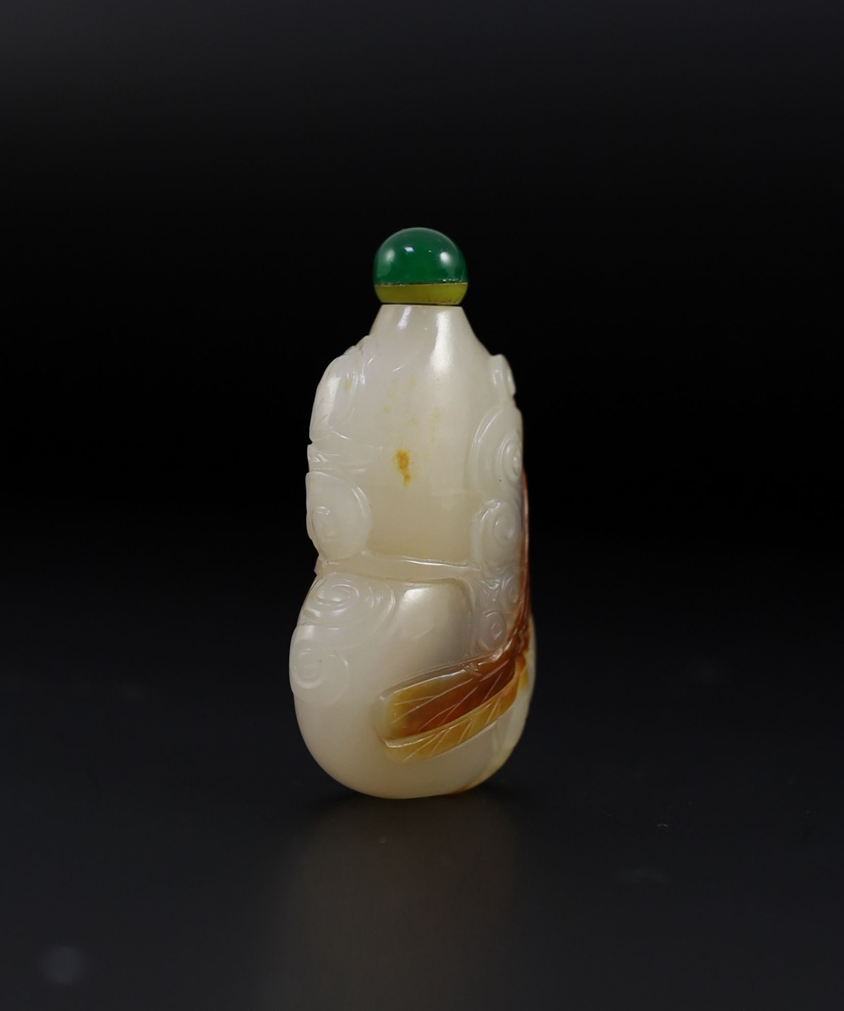 A Chinese white and russet jade snuff bottle, 19th century, 4.9 cm high excluding stopper